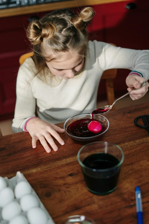 a little girl that is sitting at a table, holding easter eggs, berry juice drips, dark colours, crafting