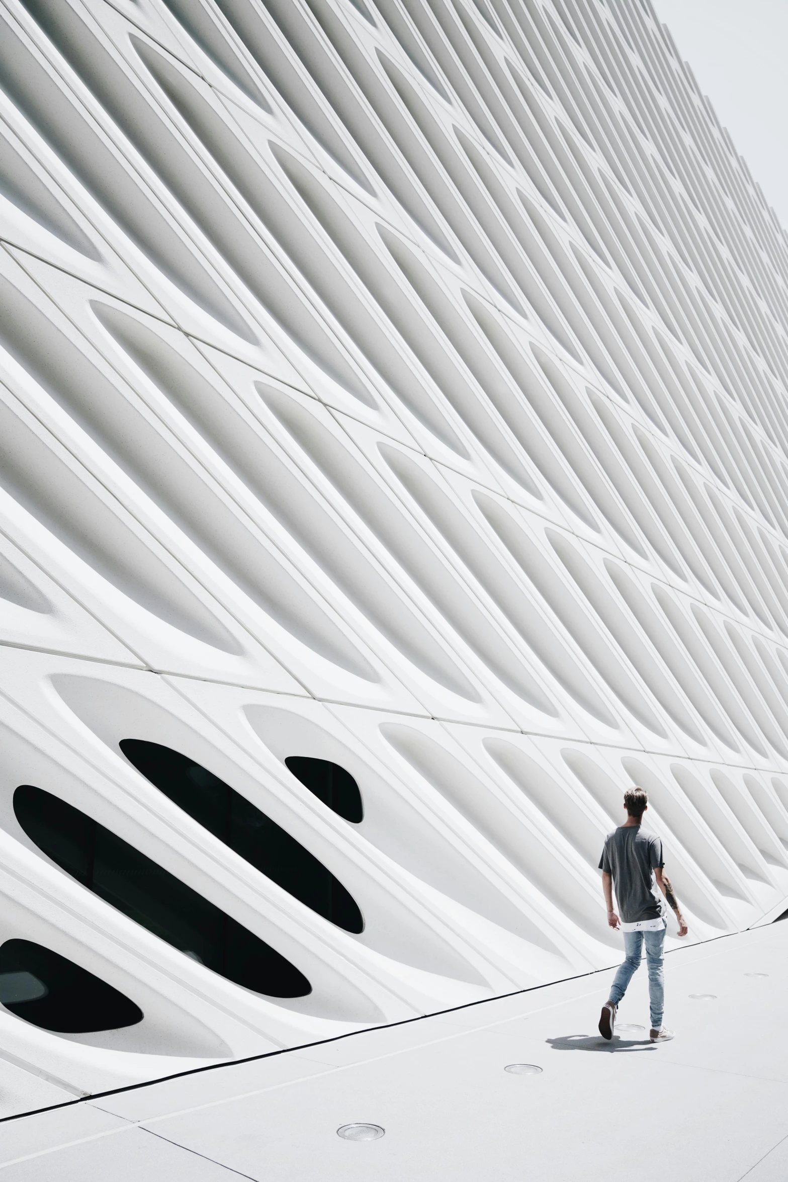a man riding a skateboard down a sidewalk next to a building, inspired by Zaha Hadid, unsplash contest winner, hypermodernism, rippled white landscape, los angeles 2 0 1 5, detail structure, a person standing in front of a