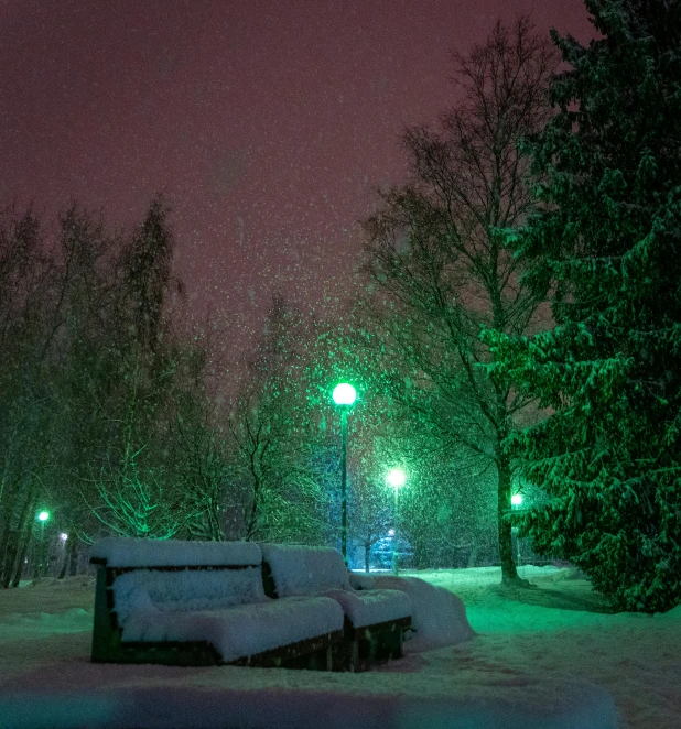 a bench sitting in the middle of a snow covered park, by Anato Finnstark, unsplash contest winner, very dark with green lights, green square, colored photo, alexander abdulov