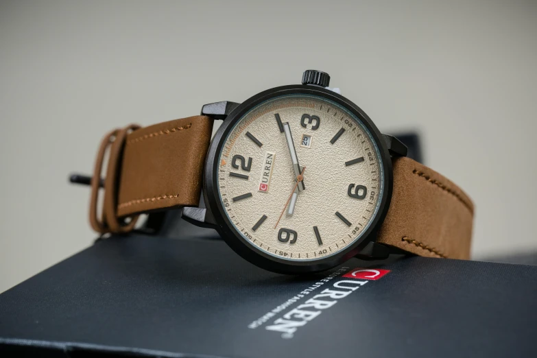 a close up of a watch on a box, a portrait, inspired by Eugène Brands, unsplash, light brown colors, chocolate. rugged, thumbnail, trending photo