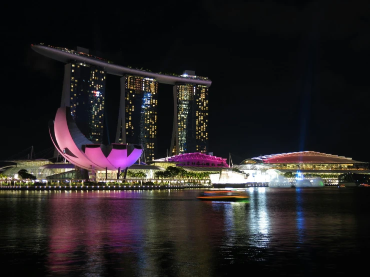 a large body of water next to a tall building, pexels contest winner, singapore esplanade, projection mapping, fan favorite, 2 0 0 0's photo