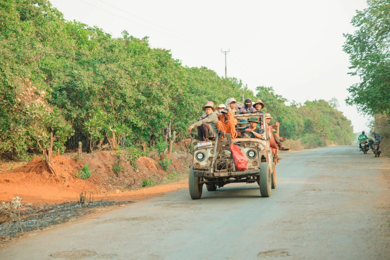 a group of people riding on the back of a truck, dirt road, in style of lam manh, rusty vehicles, profile image