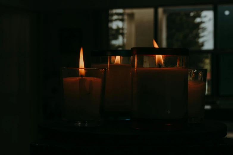 a group of candles sitting on top of a table, bathed in light, dimly light room, instagram post, front lit