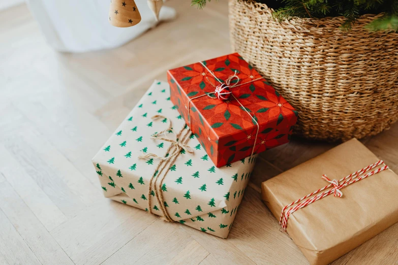 a basket filled with christmas presents next to a christmas tree, by Emma Andijewska, pexels, patterned, background image, two, birthday wrapped presents