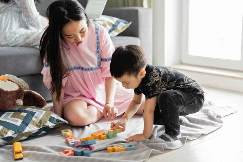 a woman playing with a child on the floor, pexels contest winner, building blocks, asian girl, ad image, thumbnail