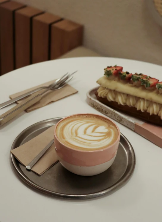 a hot dog sitting on top of a plate next to a cup of coffee, inspired by Richmond Barthé, romanticism, latte art, pink, cake, profile image