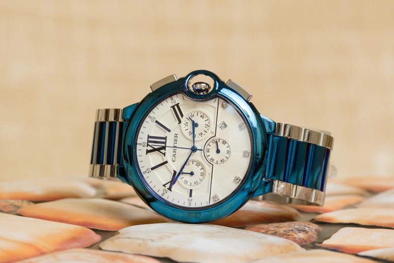 a close up of a wrist watch on a table, by Julia Pishtar, warm shades of blue, cartier, regular build, thumbnail
