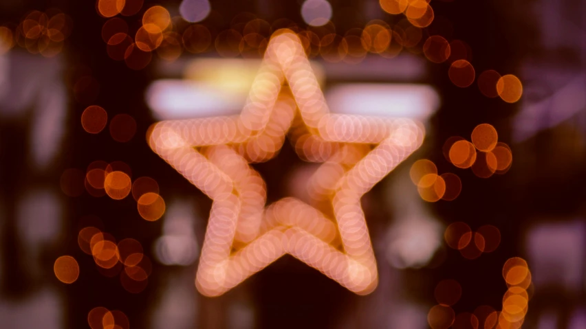 a close up of a star with lights in the background, by Niko Henrichon, pexels, hurufiyya, hasselblad film bokeh, symmetry, holiday season, brown