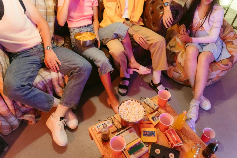 a group of people sitting on top of a couch, trending on pexels, 8 0 s asian neon movie still, snacks, wearing cargo pants, flatlay