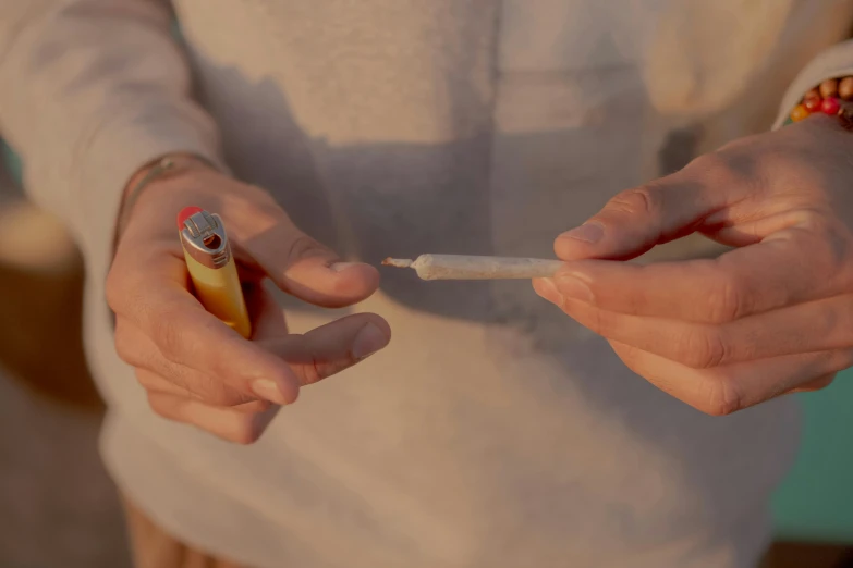 a close up of a person holding a toothbrush, smoking a joint, flares anamorphic, holding a syringe, small in size