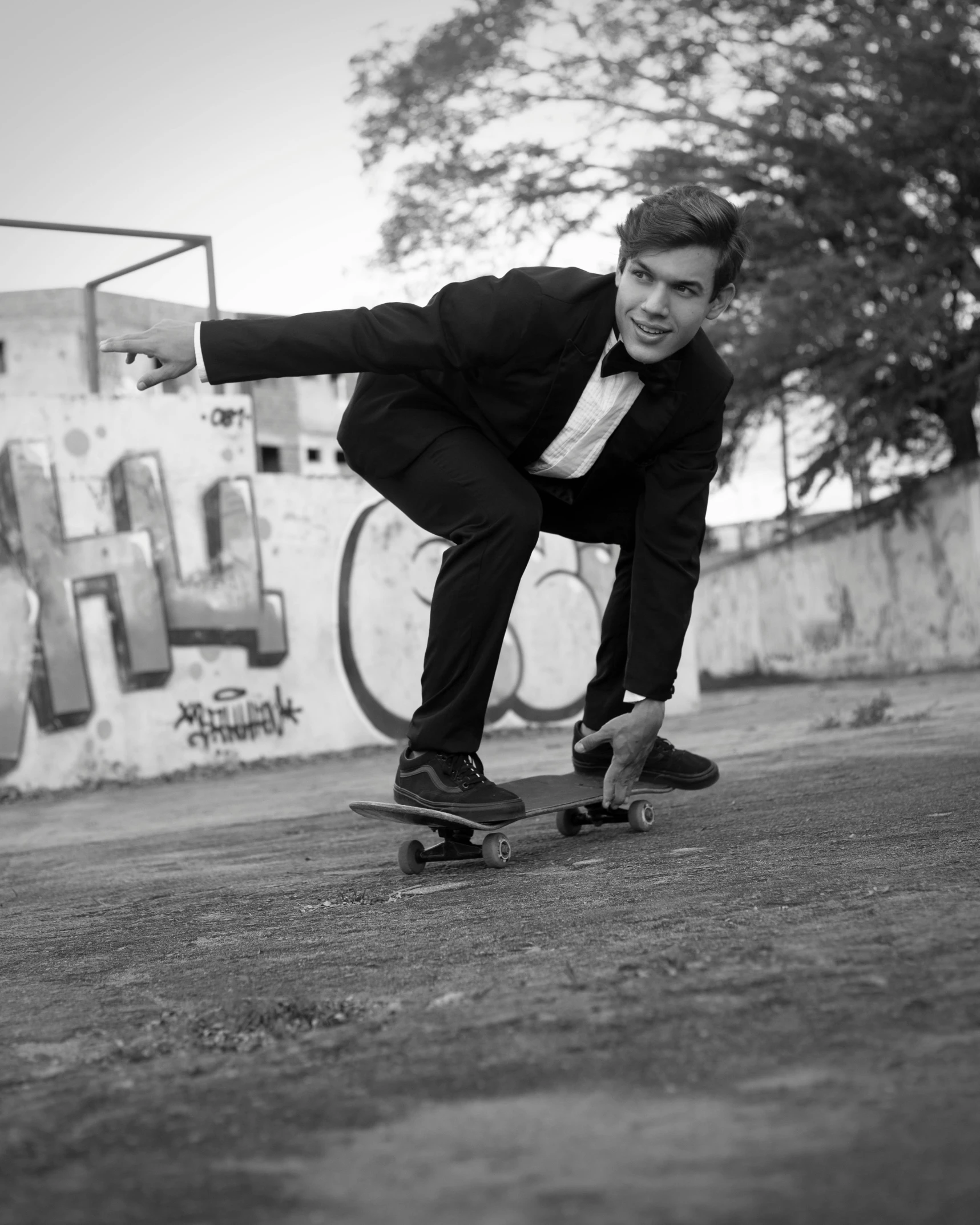 a black and white photo of a man on a skateboard, by Silvia Pelissero, wearing a tuxedo, 15081959 21121991 01012000 4k, tom jobim, action pose