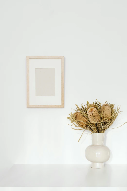 a vase with dried flowers on a white shelf, a minimalist painting, trending on unsplash, square pictureframes, minimalist line drawing, background image, beige color scheme