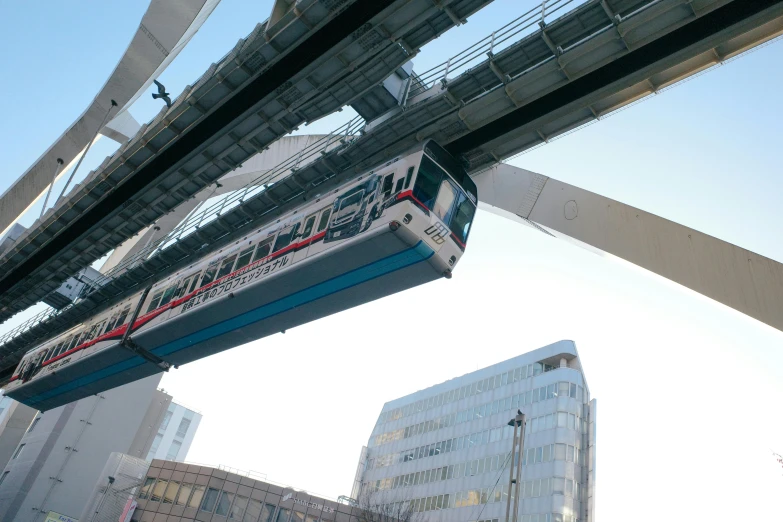 a train that is going over a bridge, skybridge towers, calarts, suspended in air, exterior photo