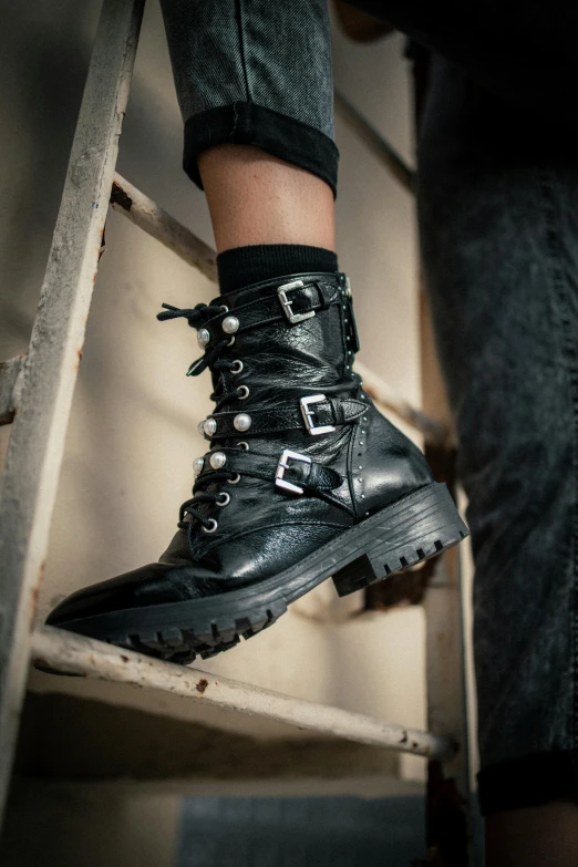 a close up of a person standing on a ladder, black leather boots, black pearls, wearing military shoes, detailed product shot