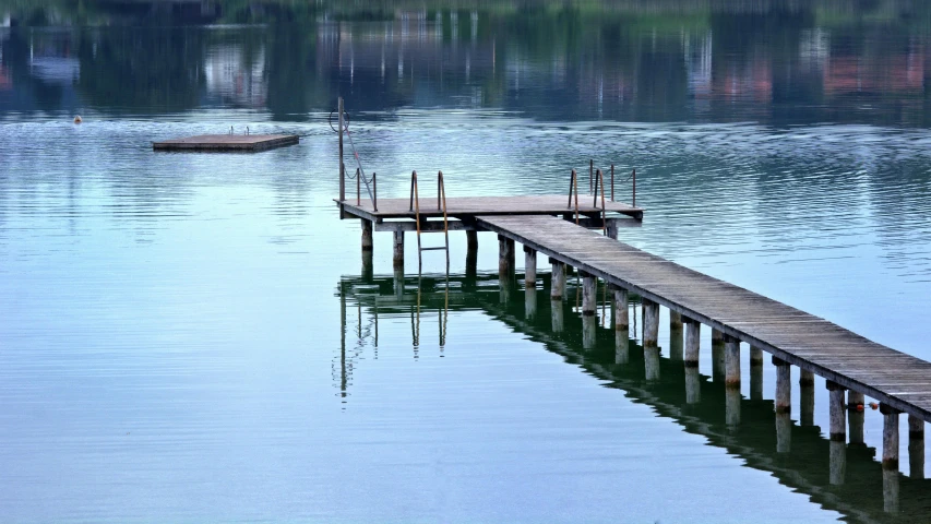 a dock in the middle of a body of water, a picture, inspired by Otakar Sedloň, hurufiyya, lake blue, mirroring, gray, green waters