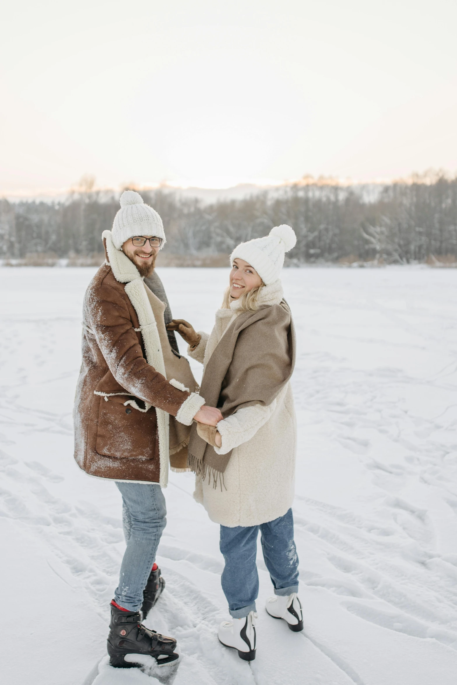 a man and woman standing next to each other in the snow, trending on pexels, winter lake setting, brown, white, promotional image