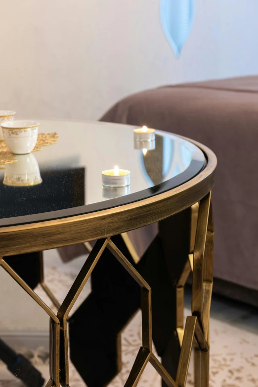 a coffee table sitting in a living room next to a couch, by Adam Marczyński, art nouveau, candles, close up angle, bronze, round design