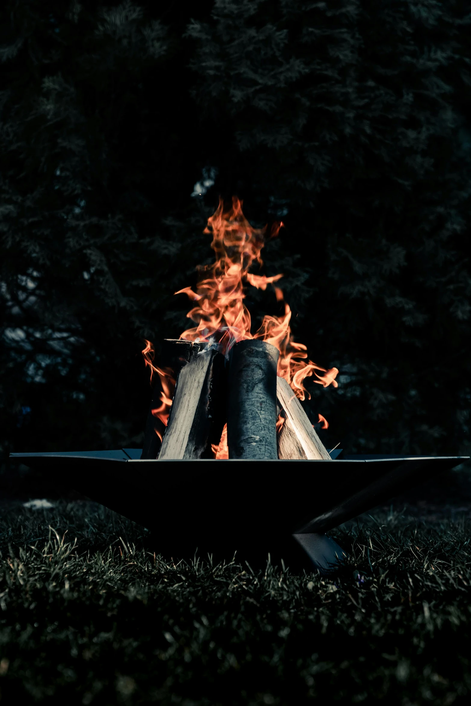 a fire pit sitting on top of a lush green field, an album cover, by Adam Marczyński, unsplash contest winner, renaissance, on black background, outdoor campfire pit, profile picture, metalwork