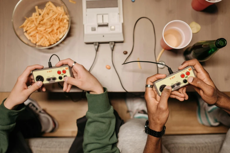 two people sitting on a couch playing a video game, a picture, by Adam Marczyński, trending on pexels, food, in retro colors, cords, spelunky