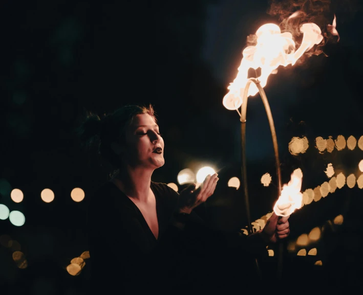 a woman holding two torches in her hands, by Emma Andijewska, pexels contest winner, renaissance, circus performance, avatar image