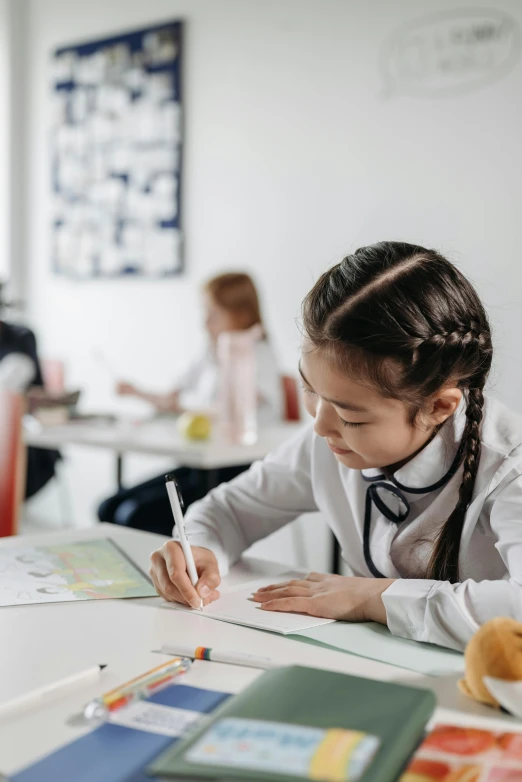 a little girl sitting at a table with a teddy bear, a child's drawing, trending on pexels, danube school, wearing a labcoat, writing on a clipboard, girl wearing uniform, profile pic