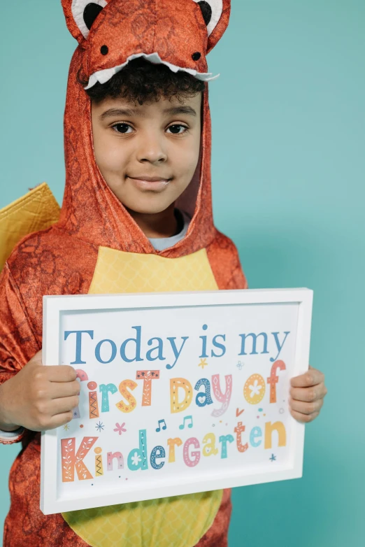 a young boy holding a sign that says today is my first day of kindergarten, shutterstock contest winner, happening, ameera al-taweel, with cape, high resolution product photo, colorful”