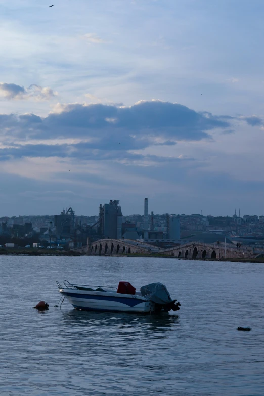 a small boat floating on top of a body of water, a picture, happening, cityscape ruins in the distance, at dusk!, can basdogan, today\'s featured photograph 4k