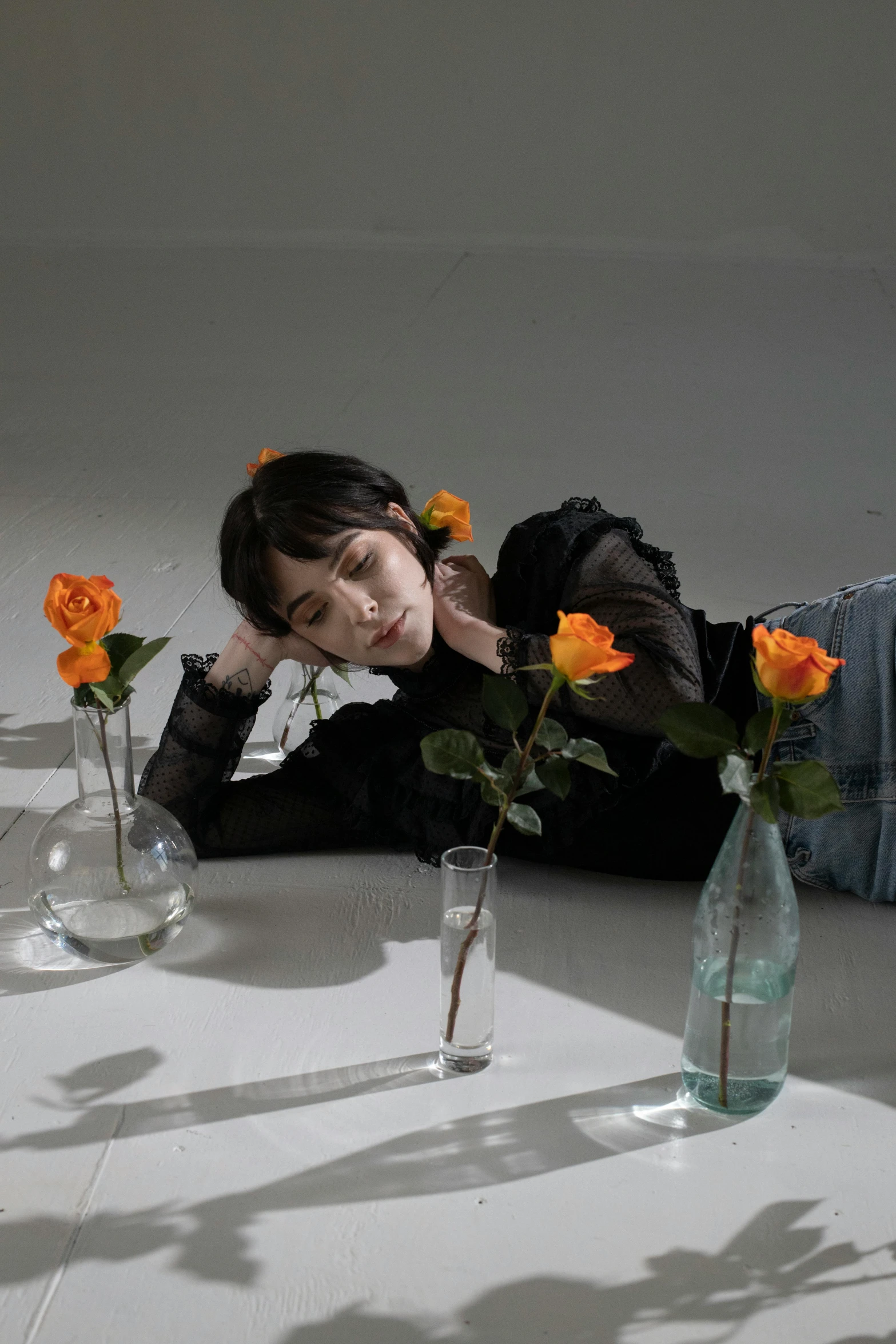 a woman laying on the floor with flowers in vases, an album cover, by Yuki Ogura, unsplash contest winner, realism, male ulzzang, full body photoshoot, androgynous person, korean girl