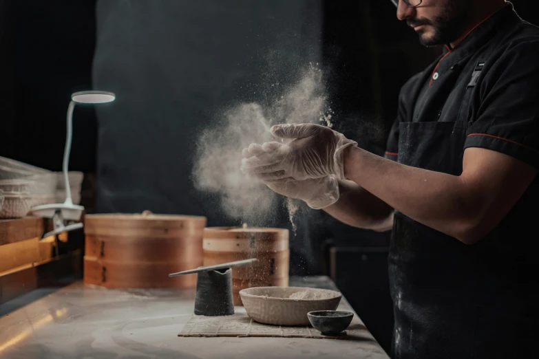 a man that is standing in front of a counter, pexels contest winner, process art, mortar and pestle, flour dust flying, steamed buns, sleek hands