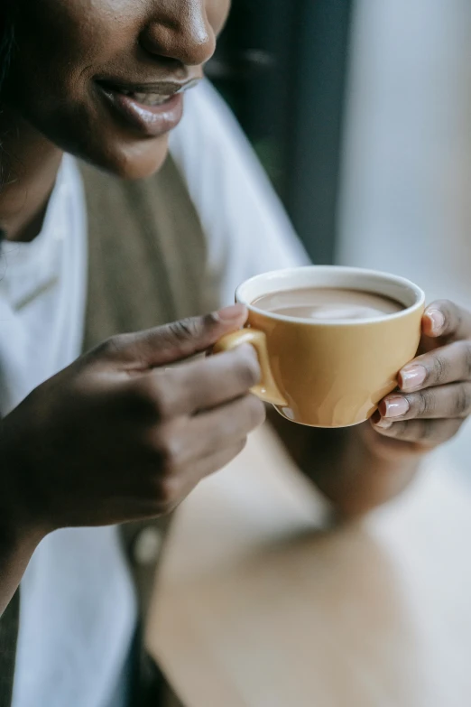 a close up of a person holding a cup of coffee, dark skinned, multiple stories, soup, creamy