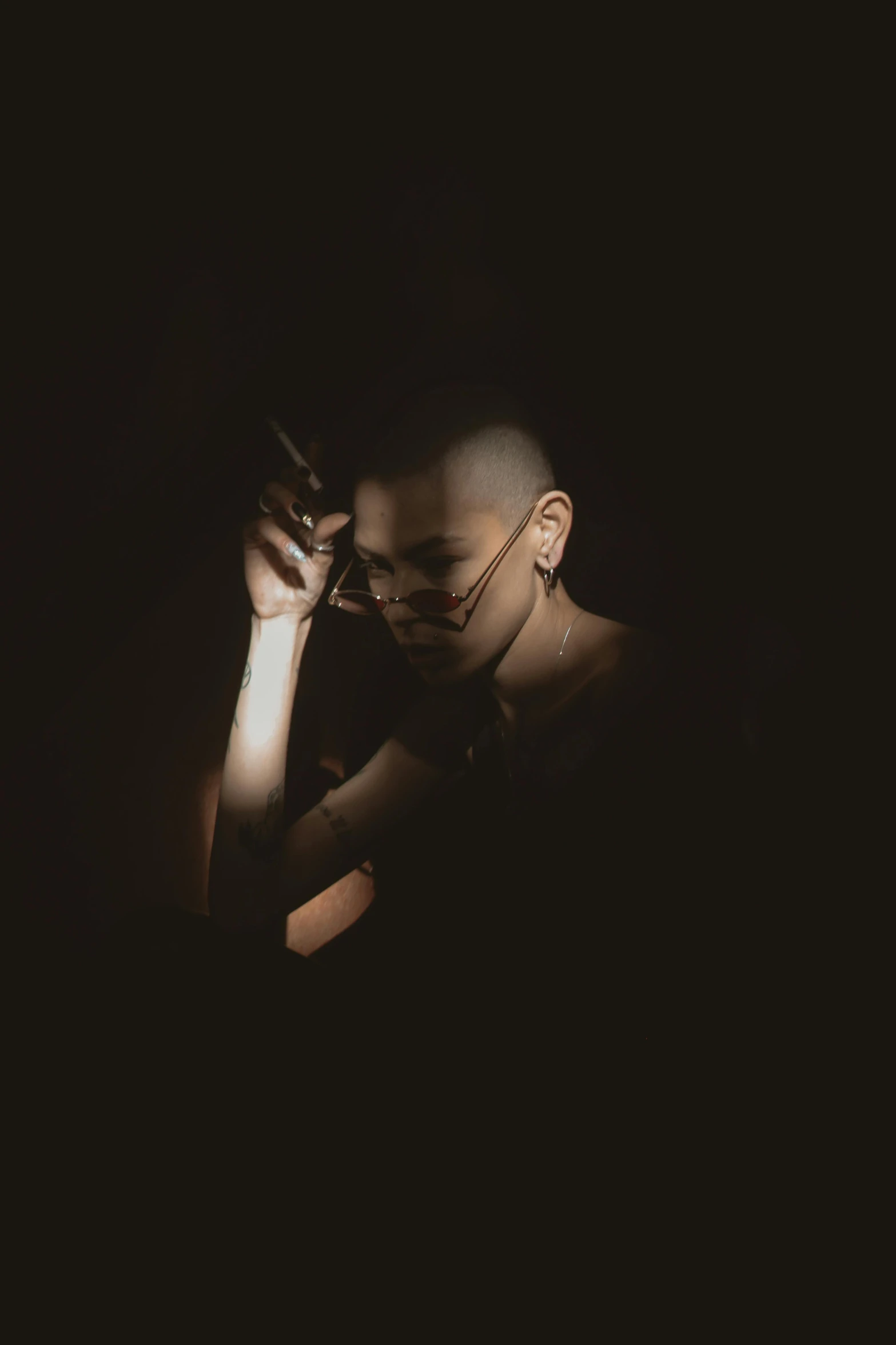 a man talking on a cell phone in the dark, an album cover, inspired by Elsa Bleda, trending on pexels, brown buzzcut, gothic girl smoking, monochrome, artists