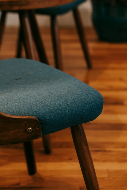 a blue chair sitting on top of a hard wood floor, by Jesper Knudsen, trending on unsplash, zoomed in shots, brown, comfy chairs, sustainable materials