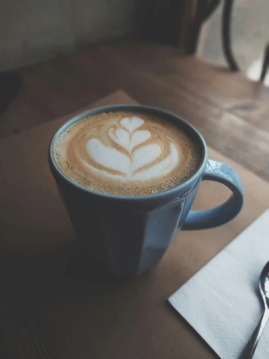 a cup of coffee sitting on top of a wooden table, by Austin English, profile image, multiple stories, latte art, thumbnail