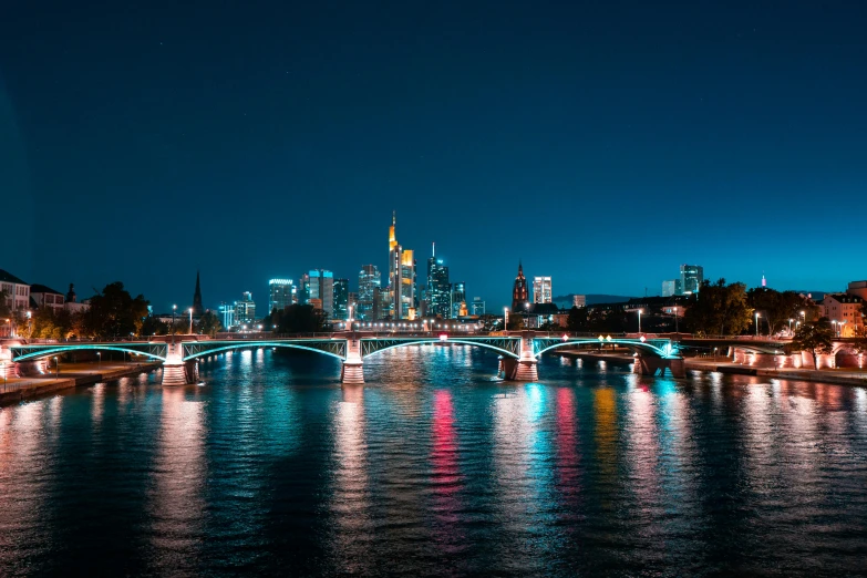 the city skyline is lit up at night, by Niko Henrichon, pexels contest winner, visual art, 1 glowing bridge crossing river, german, 15081959 21121991 01012000 4k, bright blue glowing water