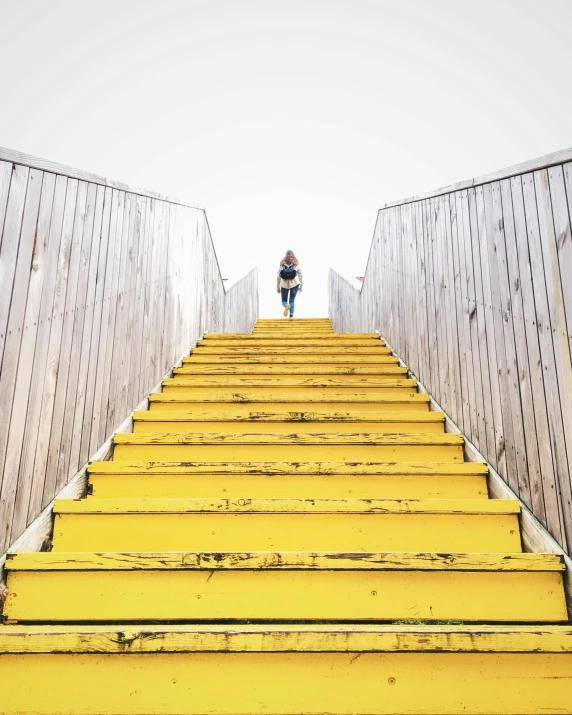 a person standing at the top of a yellow staircase