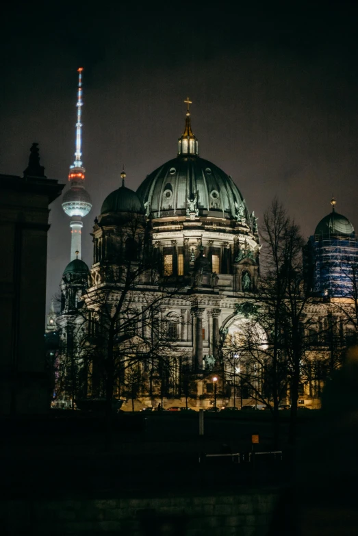 the berlin cathedral lit up at night with the tv tower in the background, a photo, pexels contest winner, berlin secession, dark gloomy church, 🚿🗝📝, neoclassical tower with dome, brown