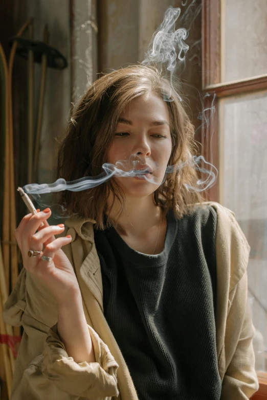 a woman smoking a cigarette in front of a window, trending on pexels, smoking a bowl of hash together, hemp, jisu choe, sydney hanson