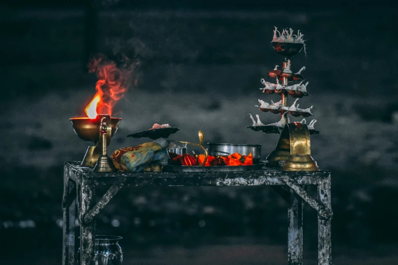 a table topped with candles and candles on top of it, pexels contest winner, hindu god, ashes and smoke columns, grey, brass and copper