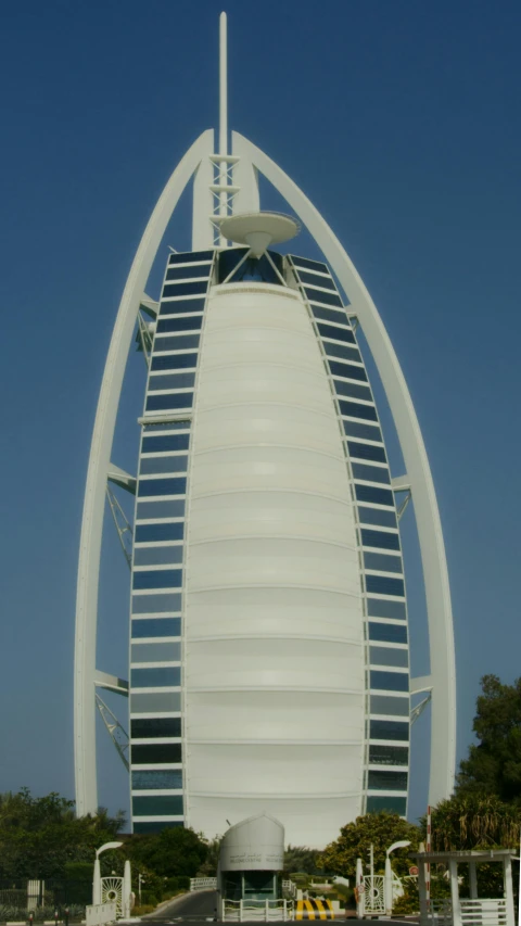 a tall white building next to a body of water, hurufiyya, golden curve structure, close-up!!!!!, dubai, 8ft tall