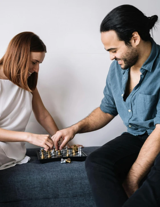 a man and a woman playing a game of chess, a colorized photo, by Arabella Rankin, trending on unsplash, carrying a tray, aussie baristas, on grey background, man proposing his girlfriend