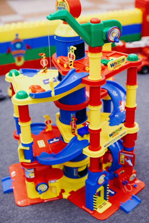 a bunch of toys that are on the ground, inspired by Rube Goldberg, reddit, pop art, fireman sam, the great marble wizards tower, set inside of parking garage, playmates toys