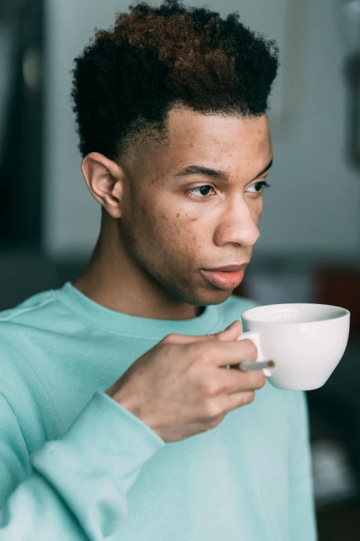 a young man holding a cup of coffee, by Daniel Seghers, trending on pexels, renaissance, mixed race, pouty face, wearing a light blue shirt, with freckles