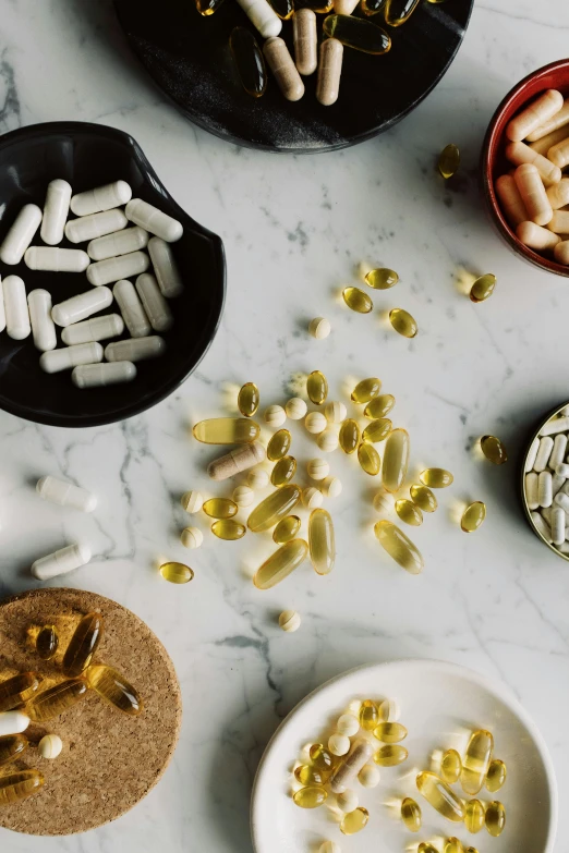 a table topped with lots of different types of pills, by Nicolette Macnamara, trending on pexels, renaissance, goop, greens, on a gray background, morning golden hour