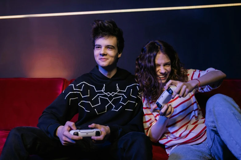 a man and a woman sitting on a couch playing a video game, a portrait, by John Luke, pexels contest winner, orelsan, studio photo, rated t for teen, gamin