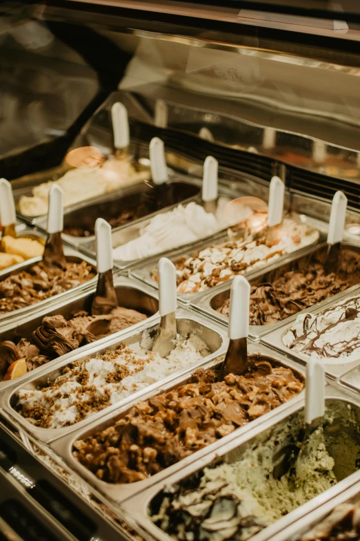 a display case filled with lots of different types of ice cream, smothered in melted chocolate, fan favorite, medium close shot, rice
