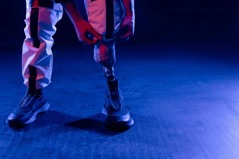 a man holding a tennis racquet on top of a tennis court, an album cover, unsplash, robotic limbs on floor, blue and purle lighting, prosthetic leg, using a exoskeleton