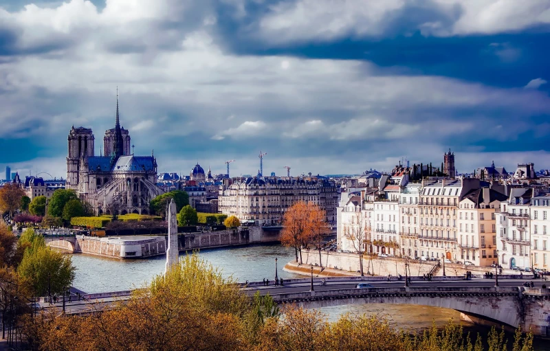 a river running through a city next to tall buildings, pexels contest winner, paris school, majestic spires, panoramic, fan favorite, autumnal