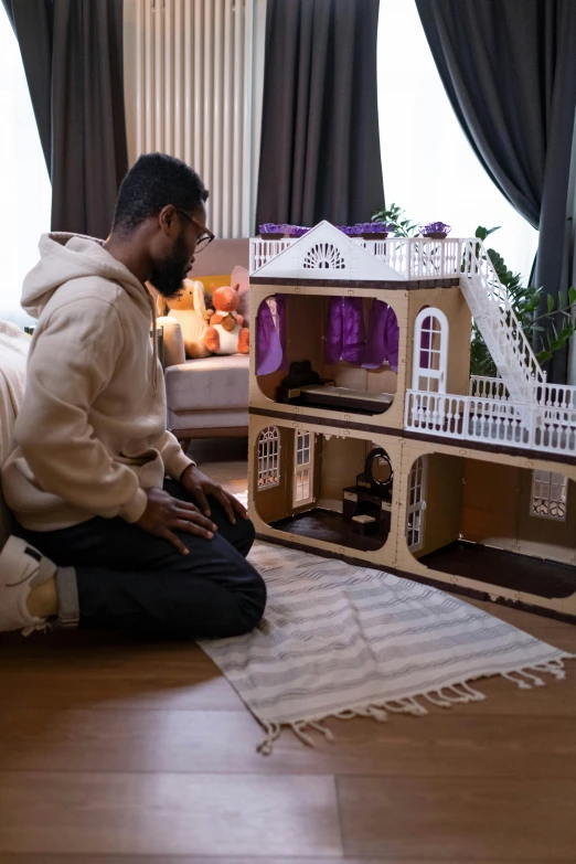 a man sitting on the floor in front of a doll house, wakanda, an arab standing watching over, professionally assembled, profile image