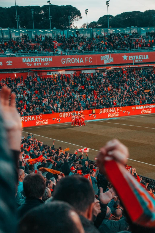 a crowd of people watching a soccer game, pexels contest winner, happening, vibrant orange, red wings, barcelona, thumbnail