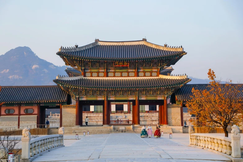 a couple of people that are standing in front of a building, inspired by Kim Hong-do, trending on unsplash, cloisonnism, monumental giant palace, square, evening sunlight, pavilion